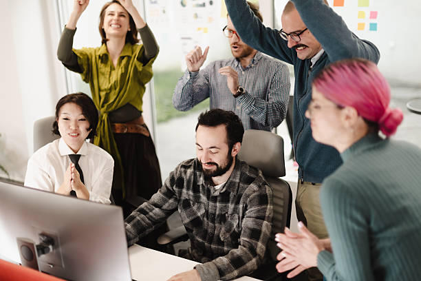 istock Group of business professionals celebrating teamwork success in a modern office setting during a project review 2241592084