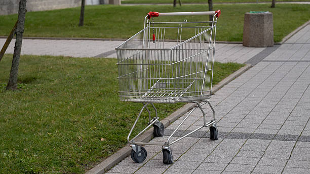 istock Empty shopping cart on city sidewalk 2241592501