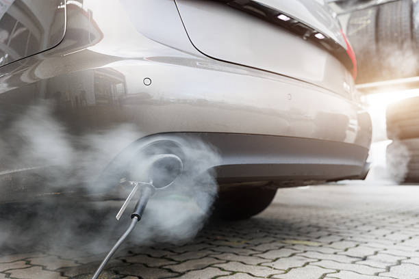 istock Car exhaust pipe emits dense smoke during emission test on city pavement. Pollution control device measures harmful gases. Service car center garage workshop.  Automobile repair check up diagnosis 2241592697