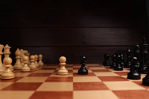 istock Black and white chess pawns in middle of chessboard. Competition concept 2241592882