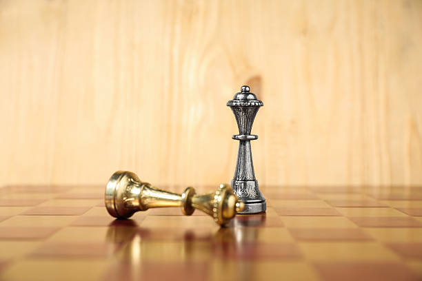 istock Silver chess queen near fallen golden one on chessboard. Competition concept 2241593079