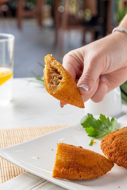 Hand holding savory brazilian coxinha snack