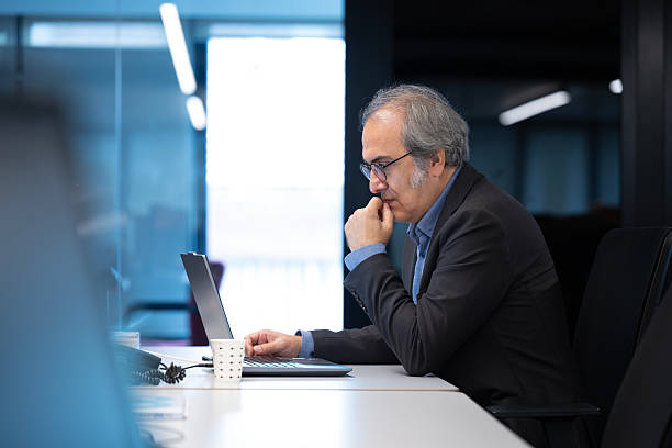 istock Businessman Thinking while Working on Laptop in Office 2241597762