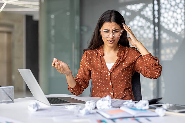 istock Stressed businesswoman having headache while working on laptop in office 2241598268