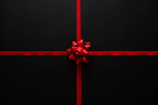 istock Black Friday background with a vivid red rosette bow centered on crossing red ribbons 2241598888