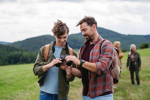 Father spending weekend with teen son on hike in nature.