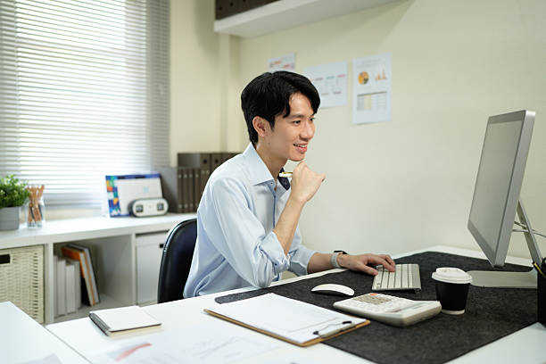 istock Business man, thinking and computer at desk in office for online research, reading email or report. Male entrepreneur person with internet connection for feedback, review and focus on project 2241604846