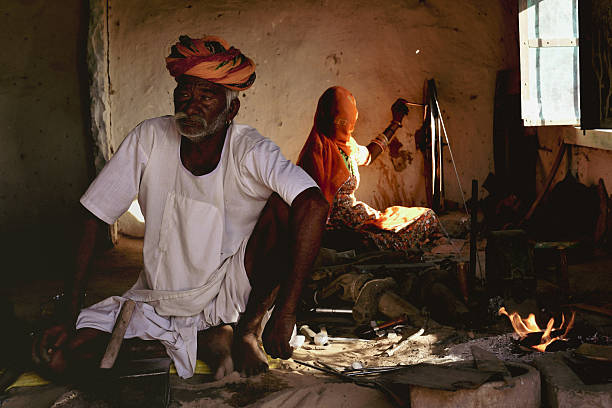 Portrait of an Indian blacksmith wearing a traditional turban, working in a rural workshop in Rajasthan, India