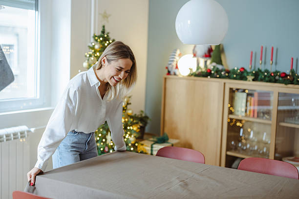istock Woman setting a festive dining table at home for Christmas and New Year celebration 2241608593