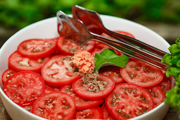 Sliced tomatoes for a tomato salad in a white plate