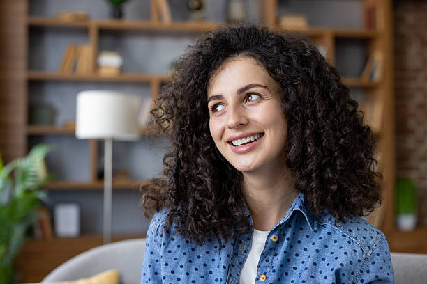 istock Happy young woman smiling looking away dreaming 2241613532