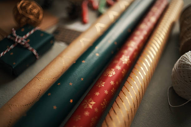 Christmas Gift Wrapping Paper Rolls Arranged on Table during Holiday Preparation