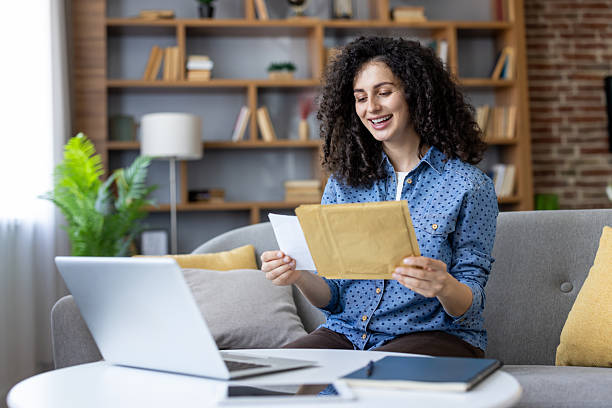 istock Happy freelancer reading a letter and smiling at home 2241617969