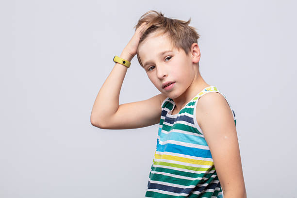 istock Young boy poses stylishly against a neutral background showcasing playful expression and casual fashion in bright stripes 2241617976