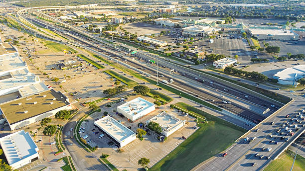 istock Stacked interchange viaduct highway in Lewisville, Texas featuring exit ramps, frontage roads, dense commercial development with strip malls, service centers, flat-roof buildings on both sides 2241618060