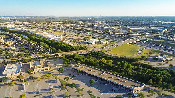 istock Large unoccupied outdoor parking at mixed-use development in Lewisville, Texas with highway, circular exit ramp, frontage road, fast food, strip malls, hotel, big box retail, apartment complex 2241618062