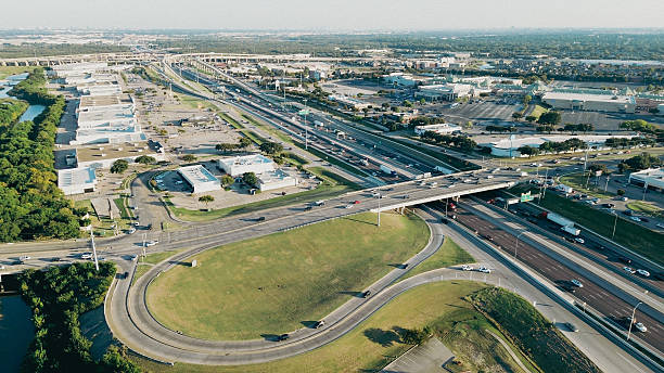 istock Busy highway exit ramp over curved Elm Fork of Trinity River in Lewisville, Texas, surrounded by commercial buildings, warehouses, and retailers with visible congestion during peak-hour traffic 2241618107
