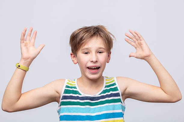 istock Excited boy expressing joy with hands raised in a cheerful setting during daytime 2241618305