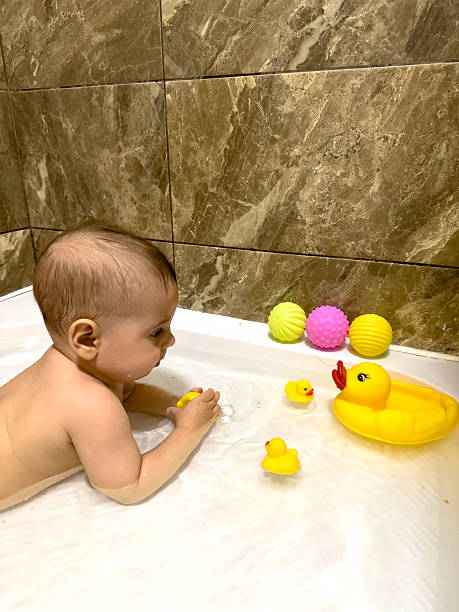 istock Baby Playing with Rubber Ducks in Bathtub 2241620616