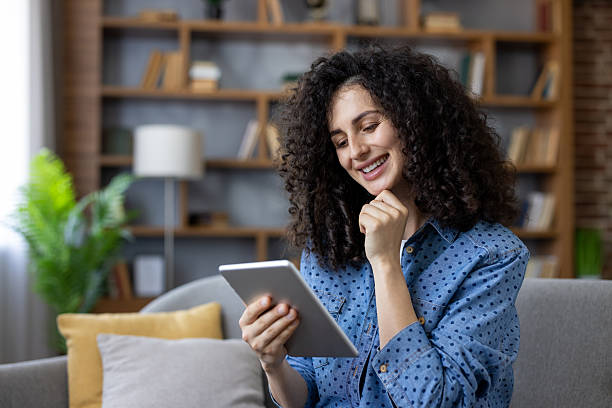 istock Happy woman using digital tablet at home 2241624418