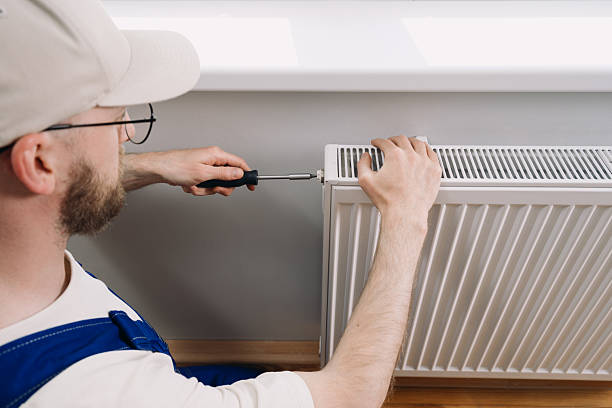 istock Man performs maintenance on home heating radiator for optimal warmth during winter 2241625848