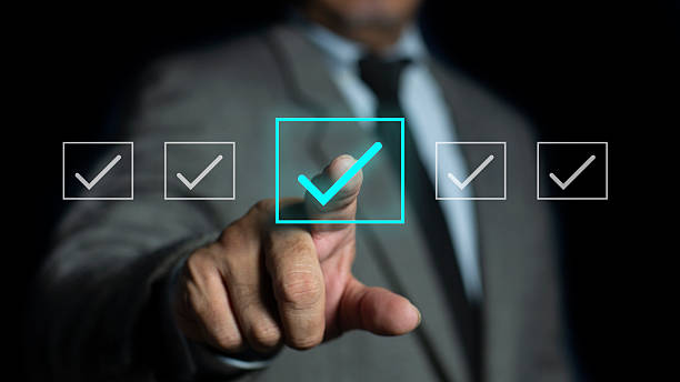 istock Businessman ticking checkmark on virtual screen. Checking marks on checklist and filling online form, answer questions of test. Audit Document concept, quality assessment, business concept 2241625890