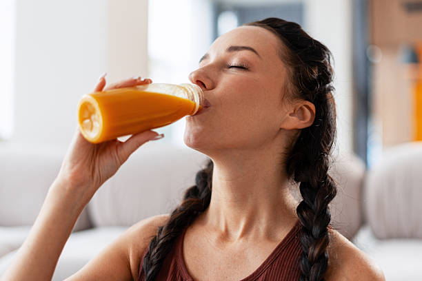 istock Woman drinking fresh orange juice feeling refreshed 2241629245