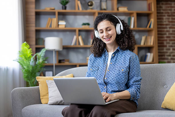 istock Woman with headphones using laptop for remote work 2241631130