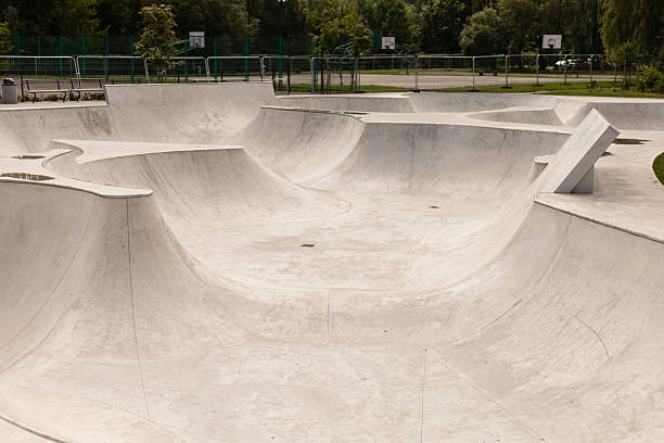 istock A spacious skate park features smooth concrete curves and ramps, inviting skaters to practice tricks and enjoy the vibrant green surroundings. It is a sunny day, ideal for outdoor fun 2241635939