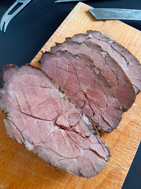 istock Delicious roast beef slices on wooden cutting board ready for dinner 2241636454
