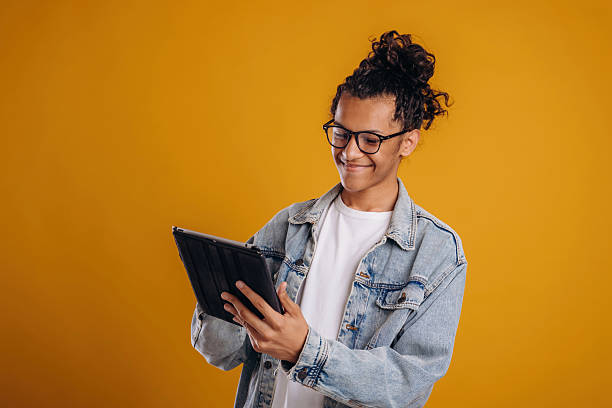 istock Digital tablet is in hands. Young guy is against yellow background 2241638942