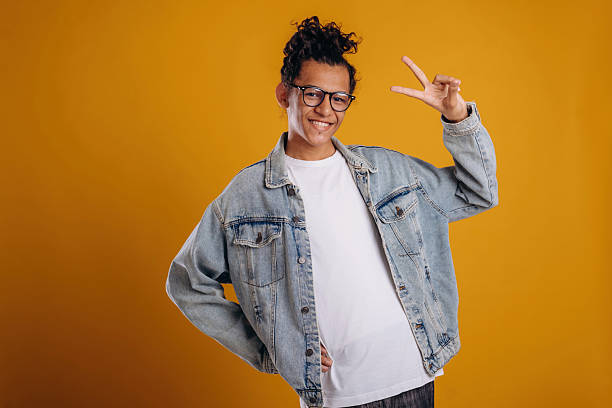 istock In jean jacket. Young guy is against yellow background 2241638960