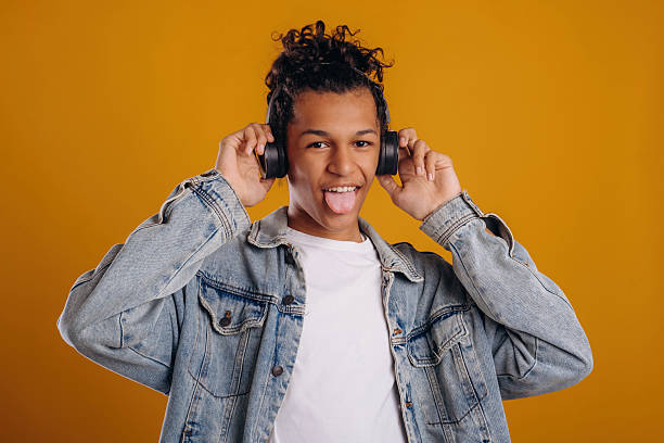 istock In jean jacket. Young guy is against yellow background 2241639152