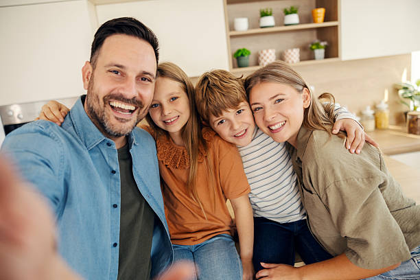 istock Happy family taking selfie in modern kitchen 2241641473
