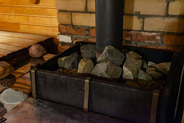 The structure features a cozy wooden sauna equipped with a traditional wood stove, complemented by decorative green bowls that add a touch of color and style to the serene environment