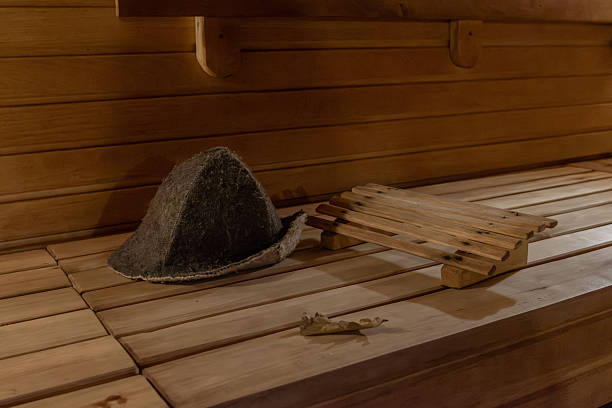 istock Felt sauna hat and wooden headrest on a bench 2241643437