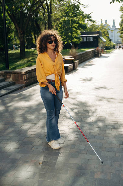 istock Using white cane. A blind woman is in the modern city at daytime 2241643442