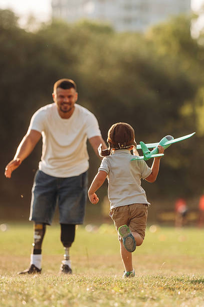 istock Bright sunlight, illuminated by it. The amputee father is with his son on the field 2241644753