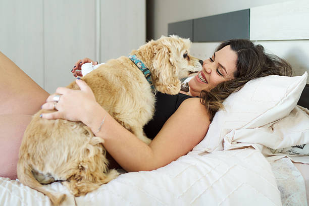 istock Woman cuddling cocker spaniel dog in bed 2241645910