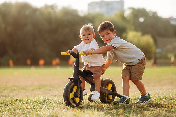 istock Kids are playing with bicycle on the field 2241645966