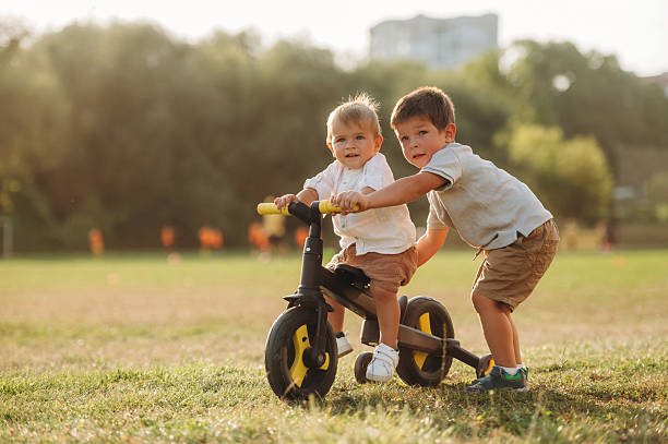 istock Kids are playing with bicycle on the field 2241645996