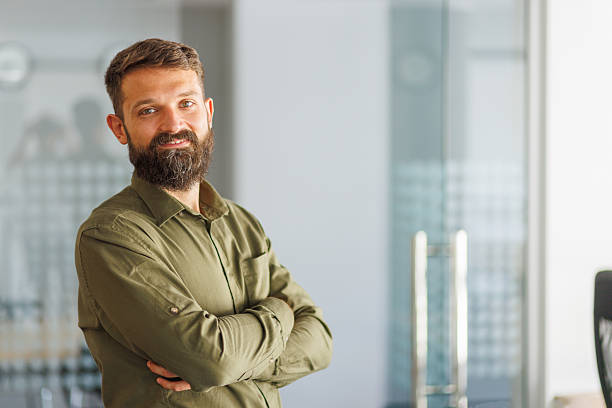 istock Bearded man standing with arms crossed, smiling 2241646994