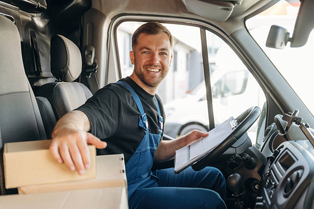 istock Checking the package. Inside of the bus with delivery service man in uniform 2241648346