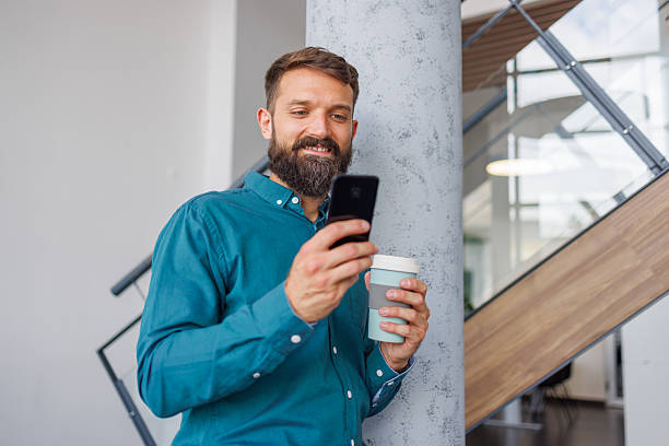 istock Smiling man telecommuting during coffee break in office 2241648772