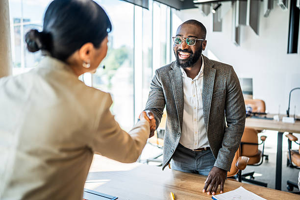 istock Business people shaking hands concluding agreement in modern office 2241650073