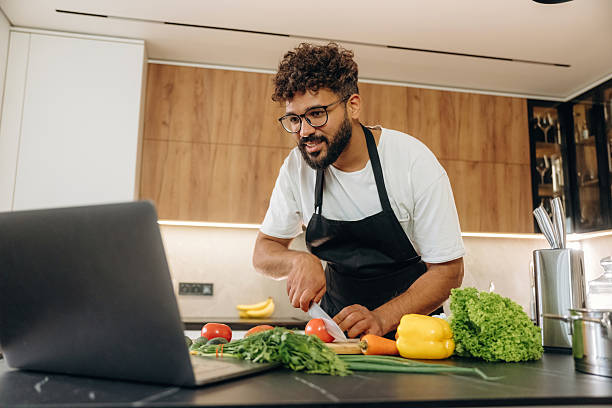 istock Slicing the vegetables. Handsome man is preparing food on the kitchen 2241650338