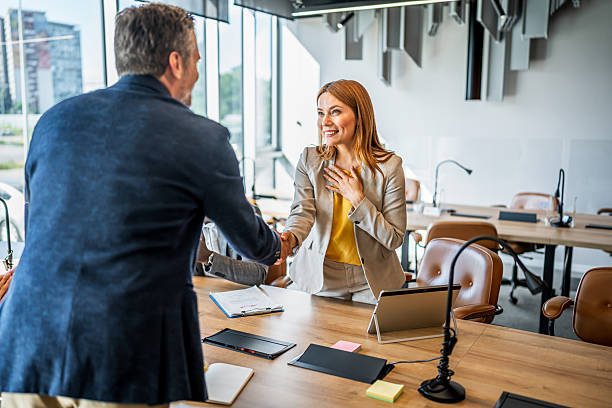istock Businesswoman shaking hands with client in office 2241650890