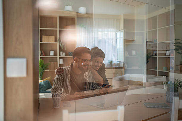 istock Happy couple relaxing at home using laptop 2241651037