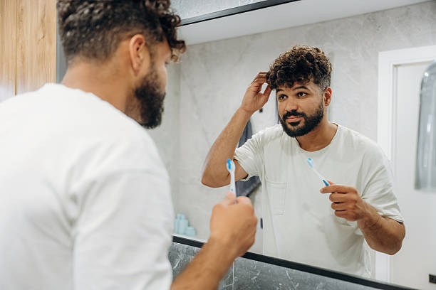 istock Brushing the teeth. Guy is in the bathroom, taking care of his appearance 2241651176