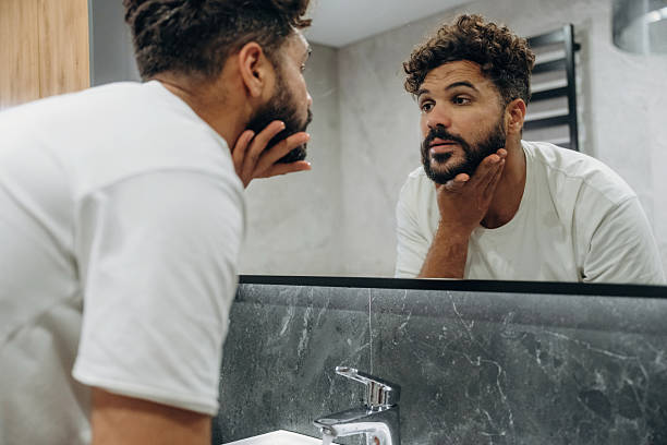istock Guy is in the bathroom, taking care of his appearance 2241651885